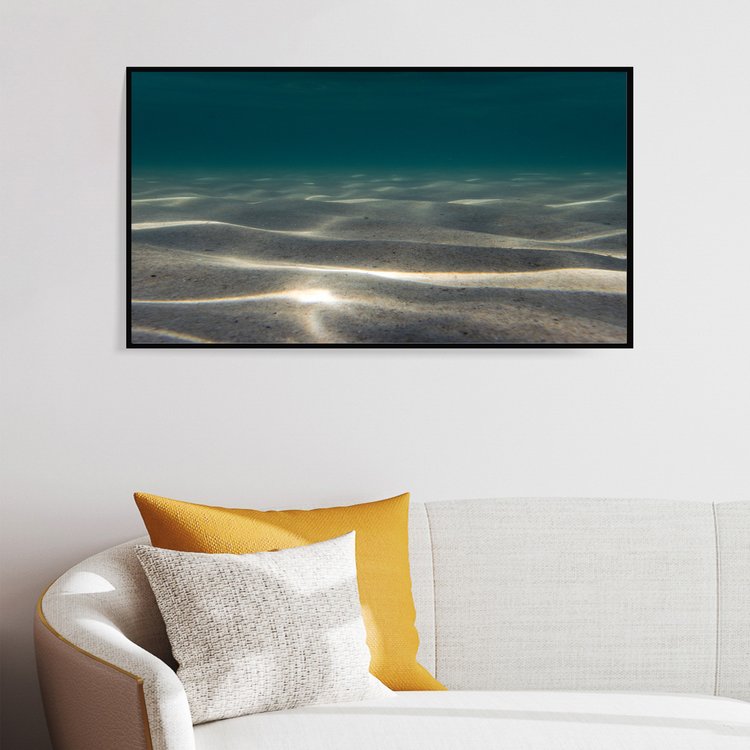 Sun on Underwater Sand Dunes is an image by Saltwater Rosie. In this image sand, shaped by ocean currents, sits quietly as sunlight finds a peaceful place to rest.

The print is framed in black on a white wall above a mdi-century modern style couch